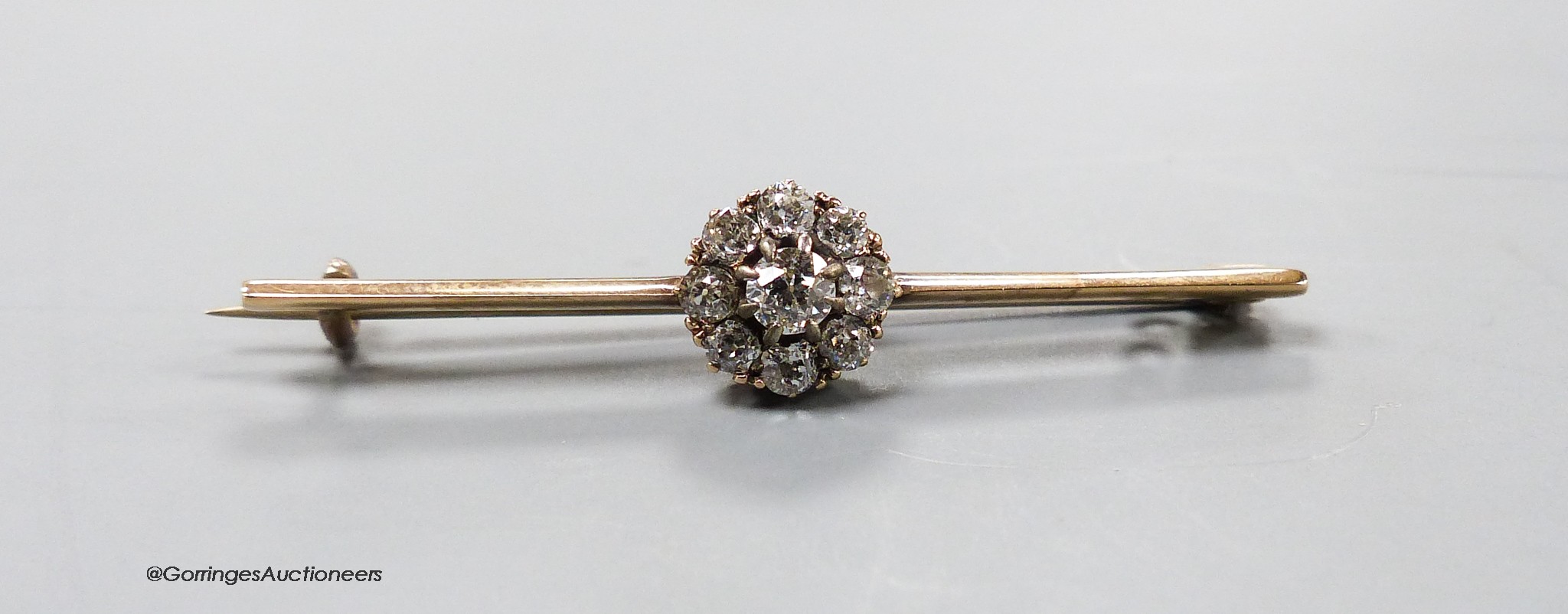 An early 20th century yellow metal and diamond cluster set bar brooch, 41mm, 2.2 grams.